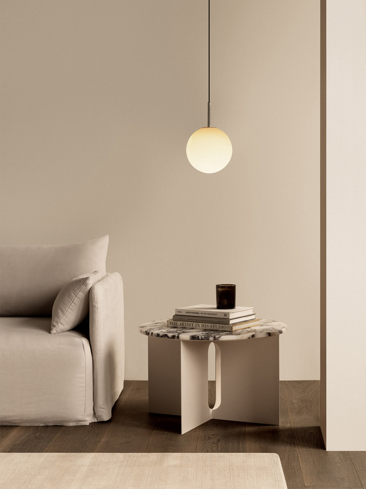 Minimal living room with beige fabric sofa, round frosted glass pendant light,