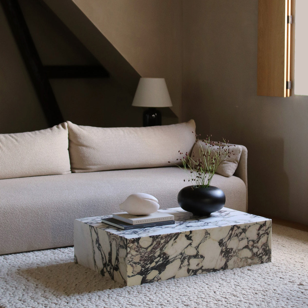 Rectangular marble coffee table with grey and purple veining, styled with stacke