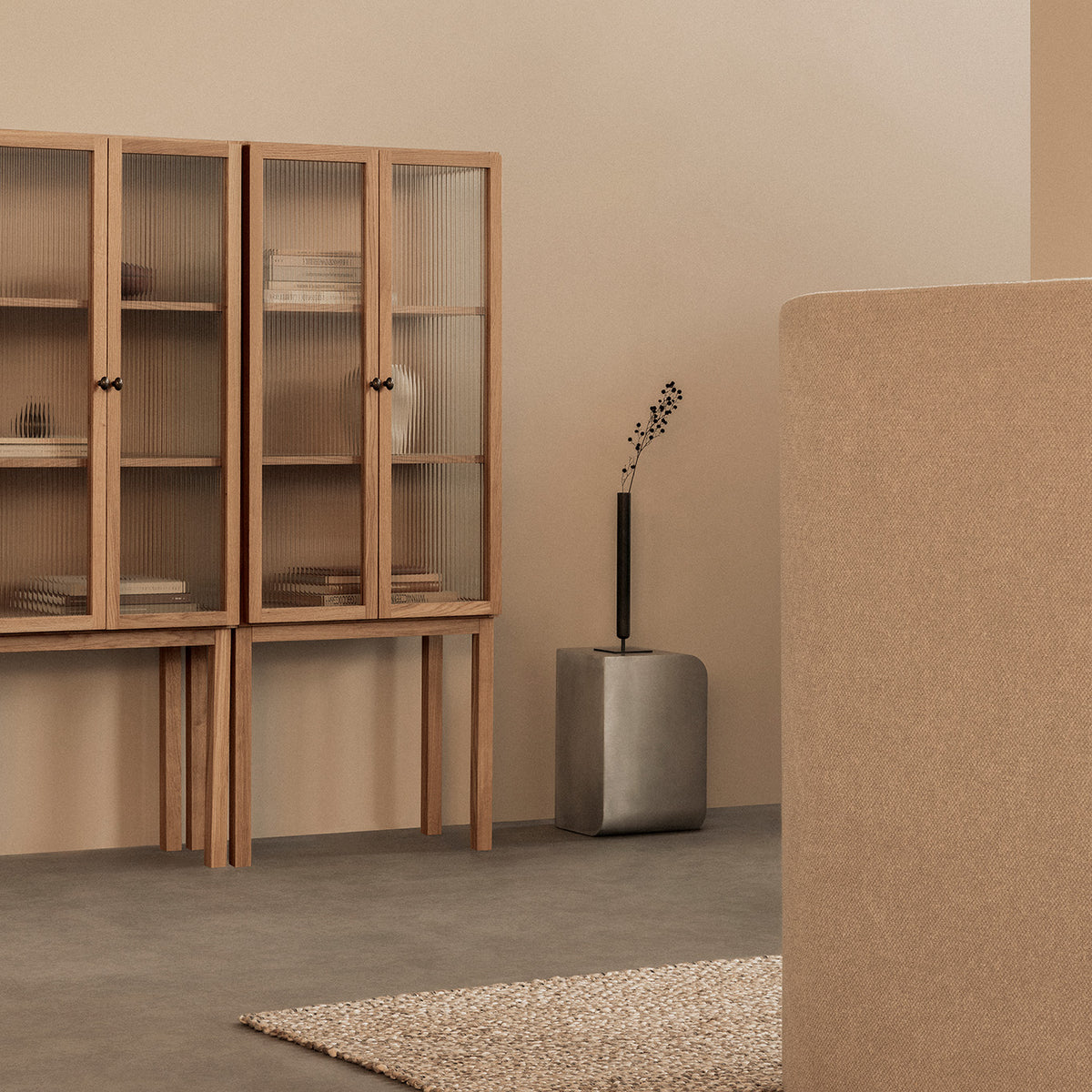 Interconnected wooden storage cabinets with fluted glass doors standing in a min
