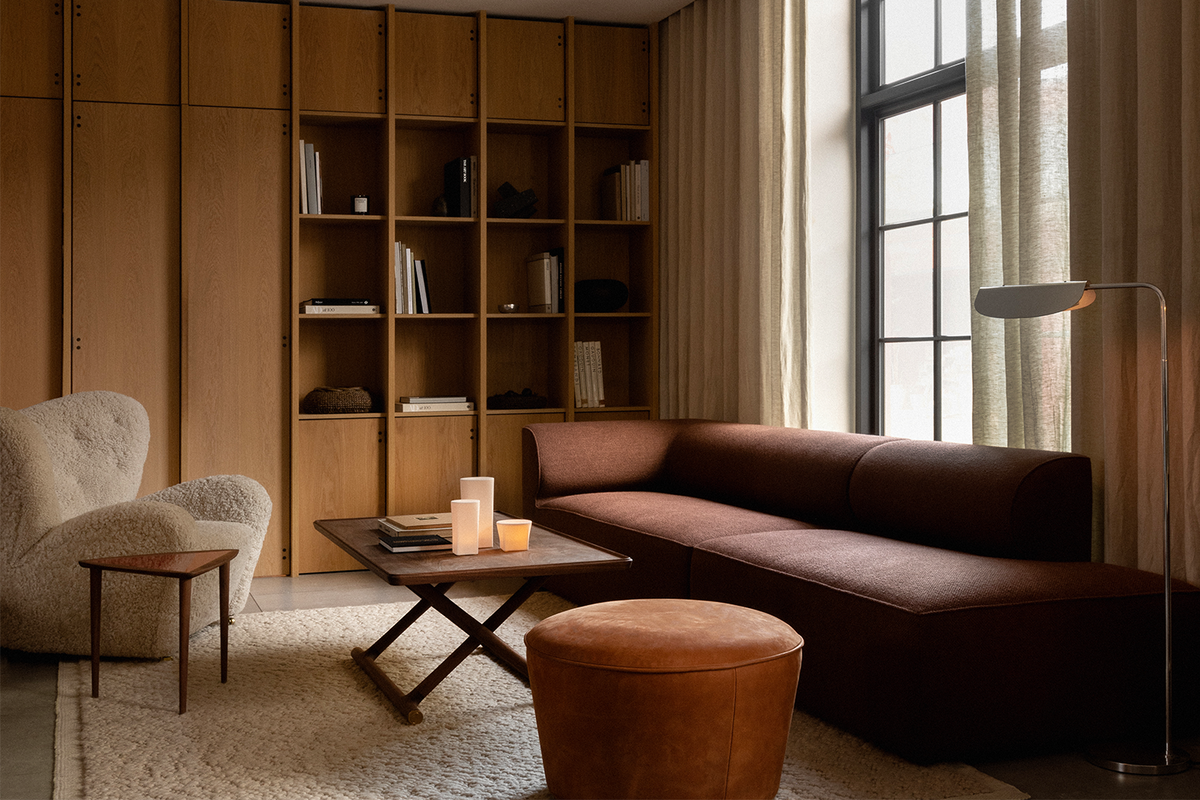 Minimal living room with brown fabric sectional, tan leather ottoman, wooden cof