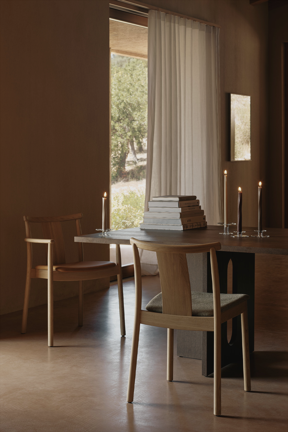 Minimal dining table scene with oak chairs, dark wooden table, stacked books