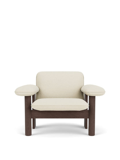 A front view of the Brasilia Lounge Chair, Low Back. It features a dark stained oak frame and is upholstered in cream bouclé.