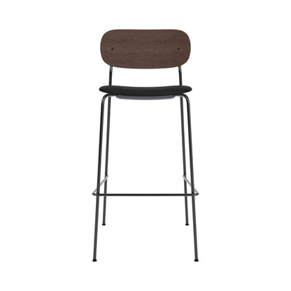 Co Bar Chair with a black upholstered seat, dark wood backrest and slender black steel frame with a built-in footrest.