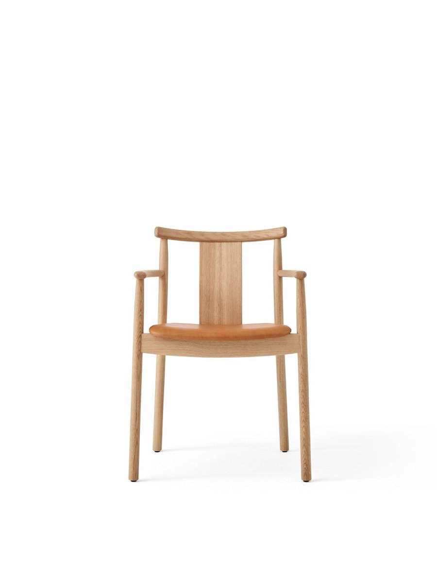 Merkur Dining Chair, With Armrests, in natural oak with a tan leather seat, shown from a front-facing perspective.