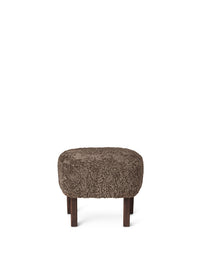 Front view of the Ingeborg Ottoman upholstered in brown Sahara sheepskin with dark stained oak legs on a white background.