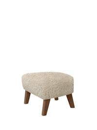 My Own Chair Ottoman with plush Moonlight sheepskin upholstery and solid walnut legs in a three-quarter studio view.