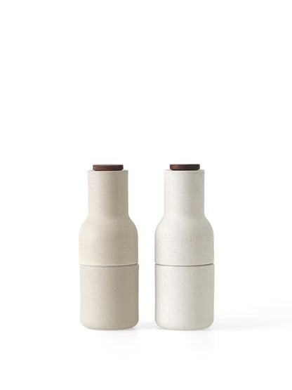Speckled Sand ceramic Bottle Grinders with walnut lids, standing against a minimalist white background.