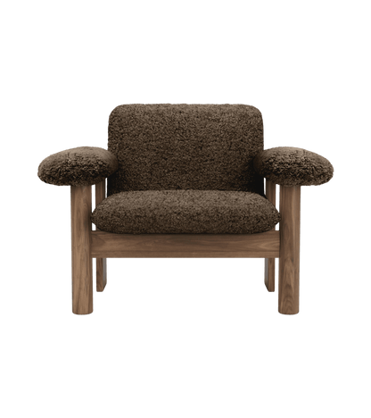 Front view of the Brasilia Lounge Chair, Low Back, upholstered in dark sheepskin with a solid wooden frame.