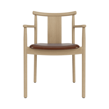 Merkur Dining Chair With Armrests in light oak with a brown leather seat, shown from the front.