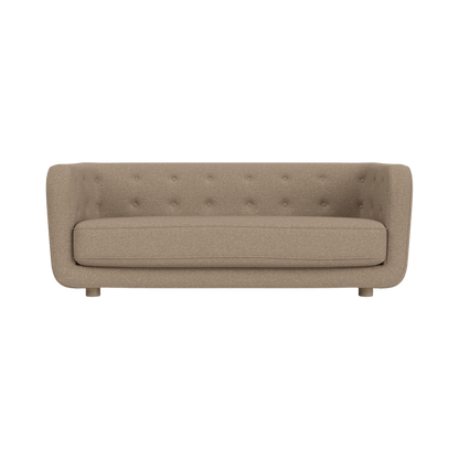Vilhelm Sofa upholstered in Logan Flint fabric with natural oak legs, showing its rounded button-detailed back.