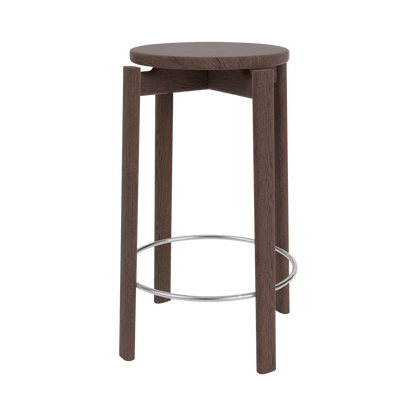Front view of the Passage Bar & Counter Stool in dark wood veneer with cylindrical legs and a circular metal footrest.