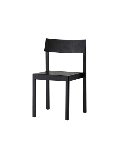Mauro Dining Chair in black oak with a minimalist wooden frame and curved backrest, shown from a three-quarter angle.