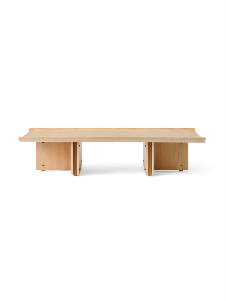 Low oak coffee table with rectangular top and split-panel pedestal legs, light natural wood finish on white background