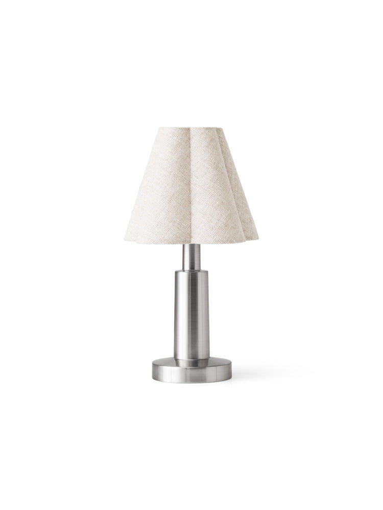 Small table lamp with pleated off-white fabric shade and brushed stainless steel cylindrical base.
