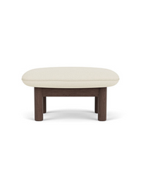 Front-on view of the Brasilia Ottoman, showing its dark wood frame with thick, round legs and a plush, cream-colored cushion