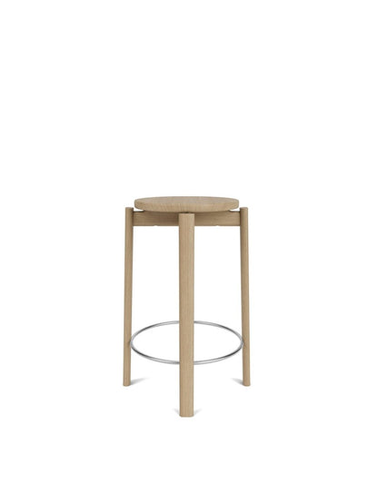 A front-on view of the Passage Counter Stool in natural oak with a round seat, four legs, and a stainless steel footrest.