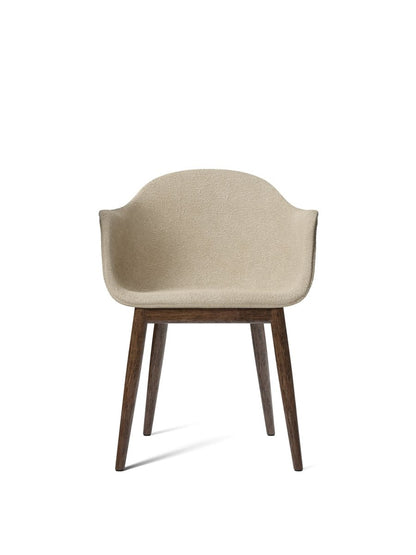 Front-on view of the Harbour Dining Chair featuring a beige bouclé upholstered shell and a dark stained oak wood base.