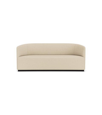 Frontal shot of the Tearoom Sofa featuring light beige bouclé upholstery, a curved back and a minimalist black base.