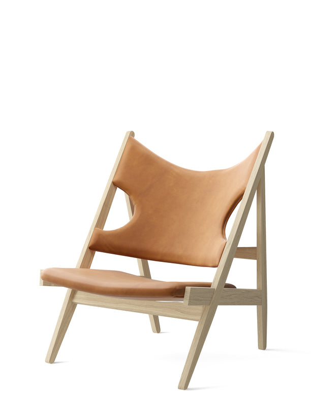 The Knitting Chair featuring a natural oak frame and cognac Dunes leather upholstery against a white background.