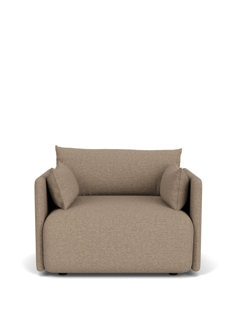 Beige textured fabric armchair with boxy shape, low back and matching bolster cushions, front view.