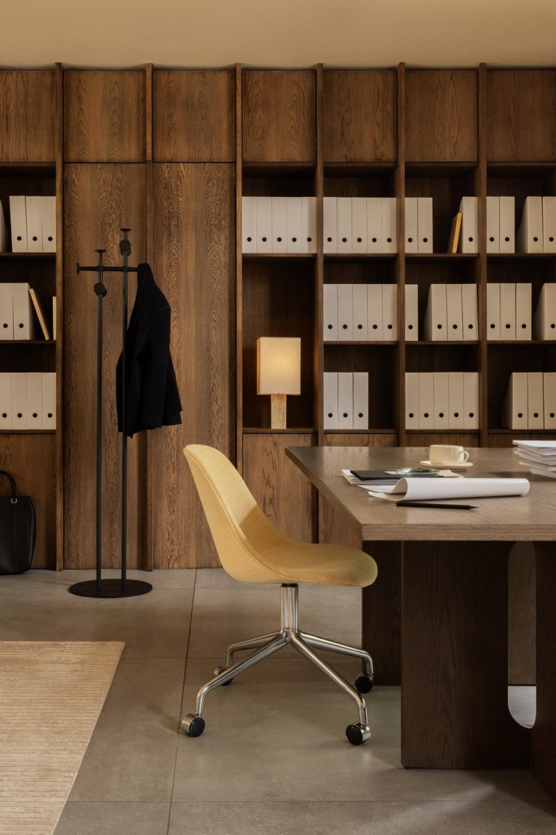 Yellow upholstered Harbour Side Chair with star base and casters at an Androgyne Dining Table in a modern office setting.