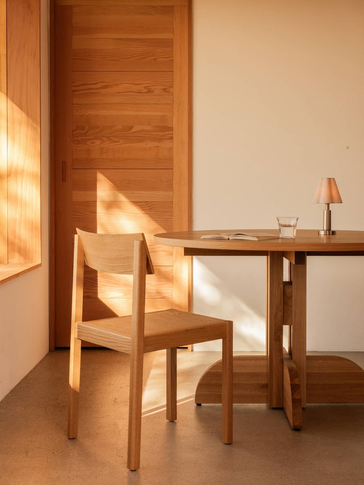 Natural oak Mauro Dining Chair and Puffin Dining Table with an Admiral Portable Table Lamp in a warm, sunlit interior.