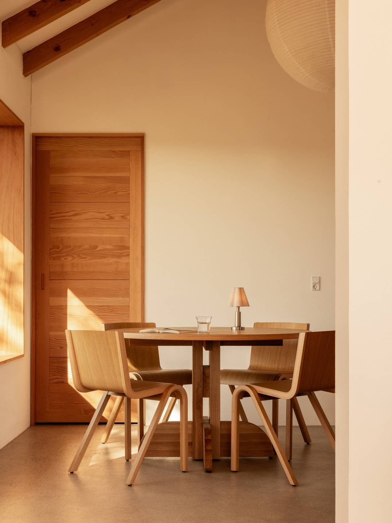 Puffin Dining Table in oak with Ready Dining Chairs and an Admiral Portable Table Lamp in a warm minimalist setting.