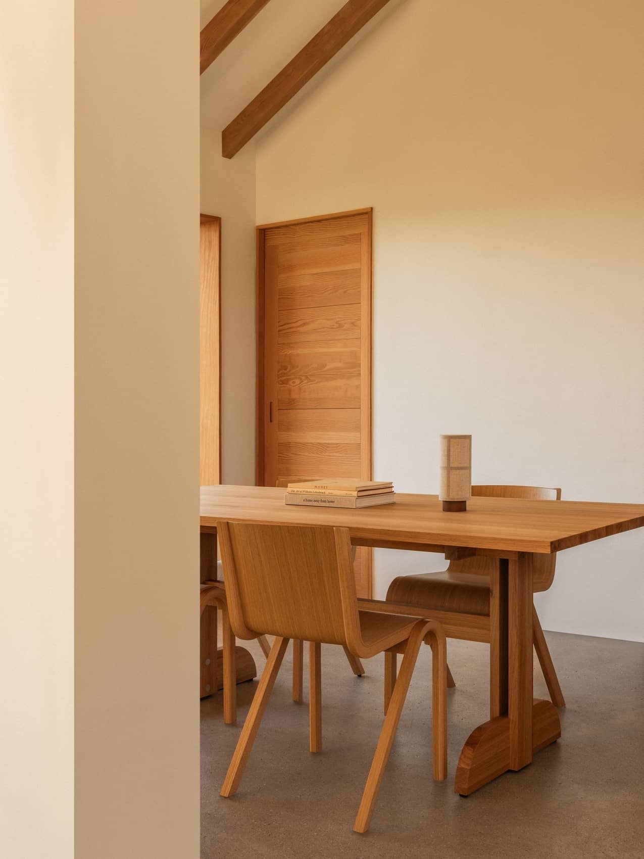 Rectangular oak Puffin Dining Table with Ready Dining Chairs and a Hashira Portable Table Lamp in a minimalist room.