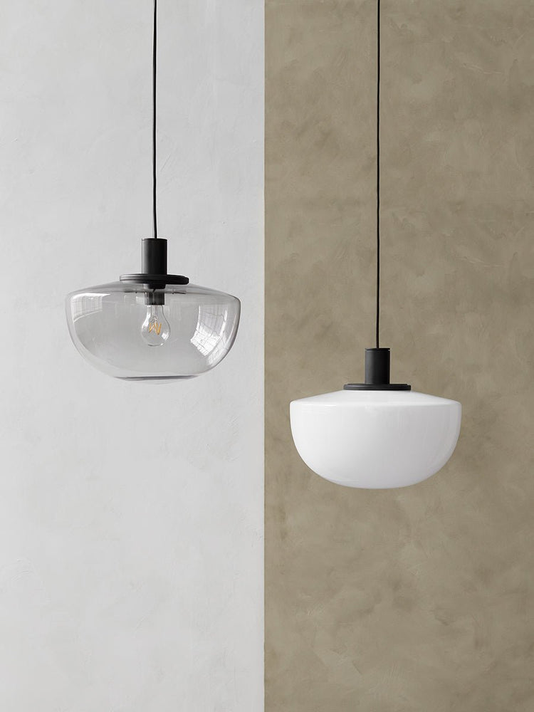 Two Bank Pendants side-by-side. Left: smoked glass against a white wall. Right: opal glass against a taupe wall.